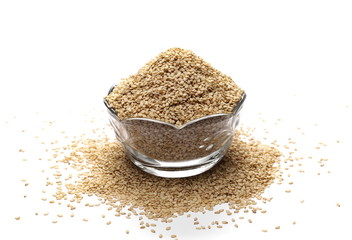 Organic integral sesame seeds in glass bowl isolated on white background
