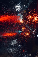 Fototapeta na wymiar lights and rain on the window in the night in the city