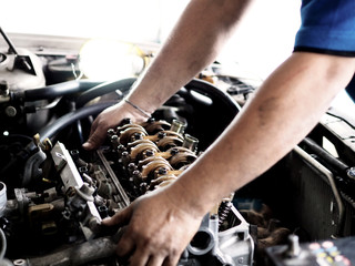 Hands of a worker checking car engine. Repair service.