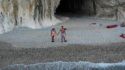 Aerial view Cala Luna beach, Young couple on vacation on the Italian Island of Sardinia, Cala Gonone Orosei coast , men and woman on the beach relaxing in the sun
