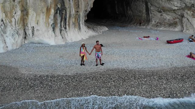 Aerial view Cala Luna beach, Young couple on vacation on the Italian Island of Sardinia, Cala Gonone Orosei coast , men and woman on the beach relaxing in the sun