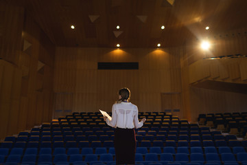 Businessawoman practicing and learning script while standing in the auditorium