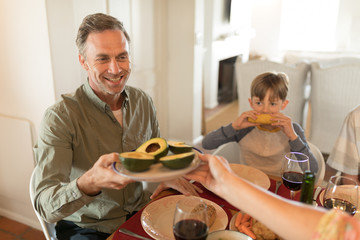Woman passing food to man on dining table