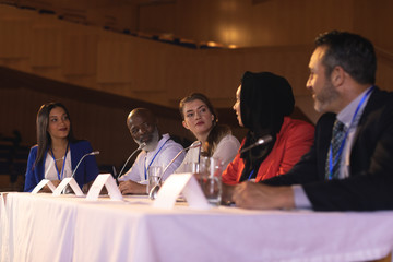 Business colleague sitting and  discussing with each other in the auditorium 