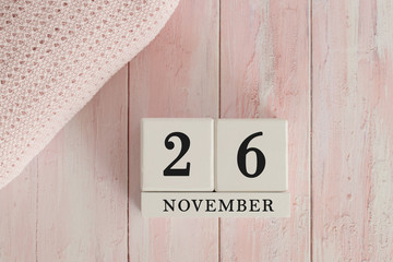 26 November Date on Cubes. Date on painted pink wood, next to baby blanket. Theme of baby due dates and birth dates.
