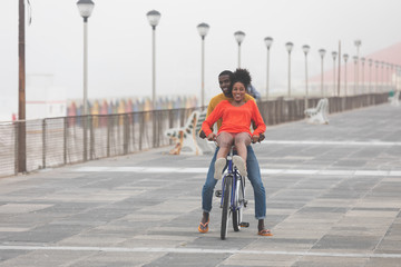 Couple enjoying at bicycle while riding at pavement