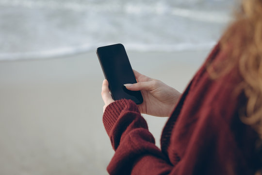 Woman using mobile phone at beach 