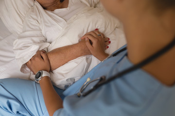 Mid section of female doctor consoling senior woman