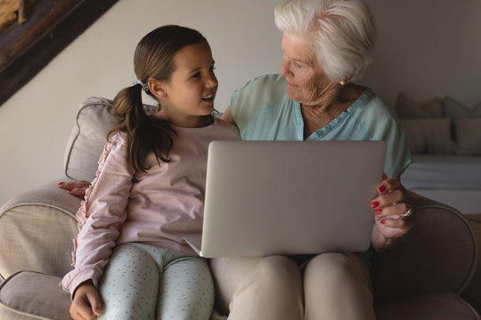 Grandmother and granddaughter discussing over laptop