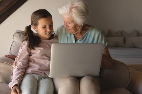 Grandmother and daughter discussing over laptop