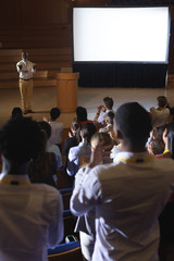 Obraz premium Businessman standing and giving presentation in auditorium 