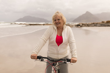 Senior woman riding a bicycle on the beach