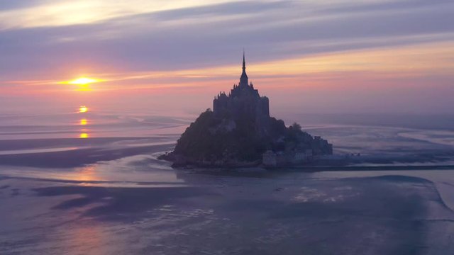 Moody amazing aerial of Mont Saint-Michel France in mist and fog in early morning.
