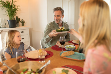 Woman passing food to man on dining table