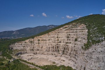 Fototapeta na wymiar Air view of a marble quarry. Panoramic view of the extraction of marble in the quarry. Technique in the marble quarry of Brescia, Italy. Open pit mine.