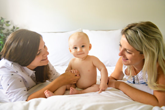 Two lesbian mother and baby on bed having fun