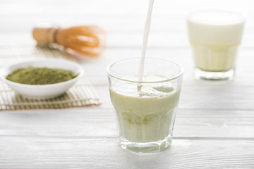 green matcha tea with milk on white table