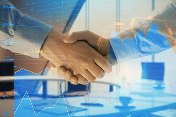 Multi exposure of financial graph on office background with two businessmen handshake. Concept of...