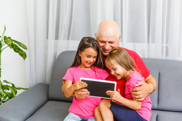 grandfather and granddaughters at home