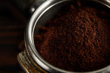 Metallic part of portafilter filled with fresh ground coffee
