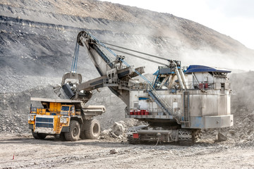 Ore loading with a powerful excavator. Loading a large mining truck.