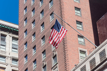Upward view waving American flag on federal buildings in downtown Chicago
