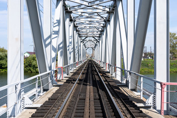 Empty long railway metallic bridge with rails. sunny day