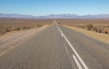 Fototapeta na wymiar The N12 highway runs in places through the arid Klein Karoo region of South Africa image in landscape format with copy space
