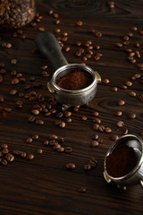 Naklejka premium Portafilters with ground coffee on dark wooden surface with coffee beans