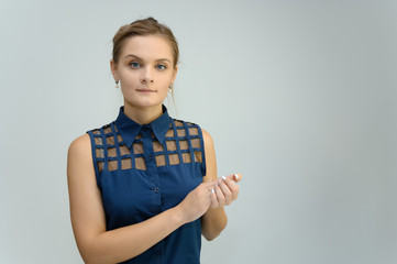 Studio photo a waist-high portrait of a pretty young woman girl in a business suit on a white background. He stands right in front of the camera, explains, with emotion.