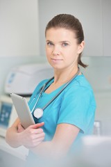 Portrait of nurse with digital tablet standing at clinic