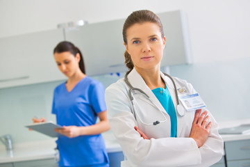 Fototapeta premium Portrait of confident doctor standing against nurse at clinic