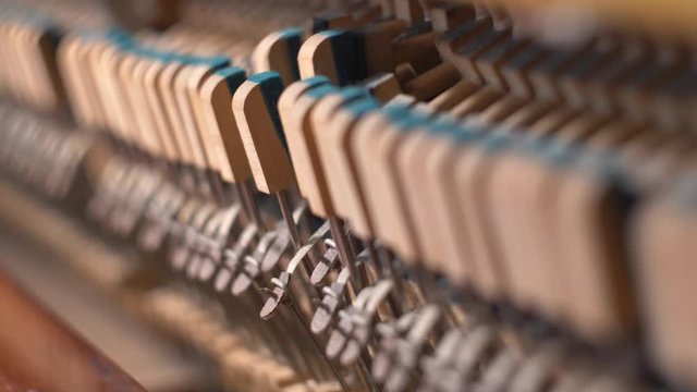 Upright Piano Mechanism Hammers Striking Strings When Song is Played by Musician