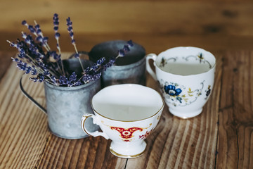 Tasses en porcelaine anciennes et pots en métal lavande sur une table en bois