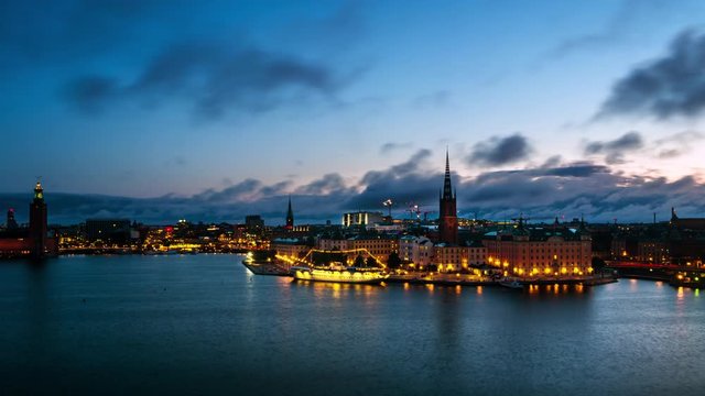 Stockholm, Sweden. Time-lapse of Gamla Stan in Stockholm, Sweden with landmarks like Riddarholm Church during the sunrise. View of old buildings and cloudy sky in morning, zoom in
