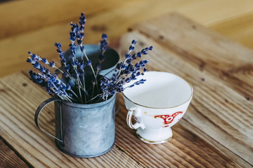 Tasses en porcelaine anciennes et pots en métal lavande sur une table en bois