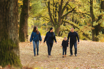 Obraz premium Happy family walking in the park. Mom dad and two daughter
