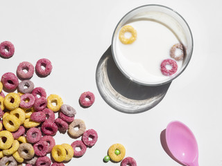 Glass of milk and cereal on white background