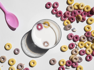 Top view glass of milk surrounded by cereals