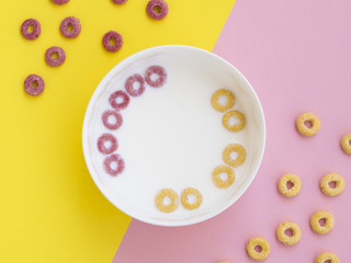Pink and yellow fruit cereal loops in a bowl
