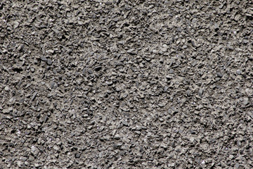 The wall consists of stone chips of dark color on a flat surface.
