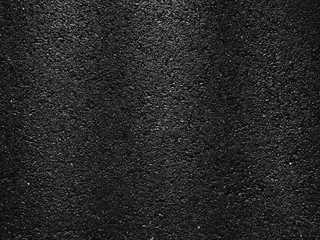 wet asphalt road with dark shadow of fence and light of morning