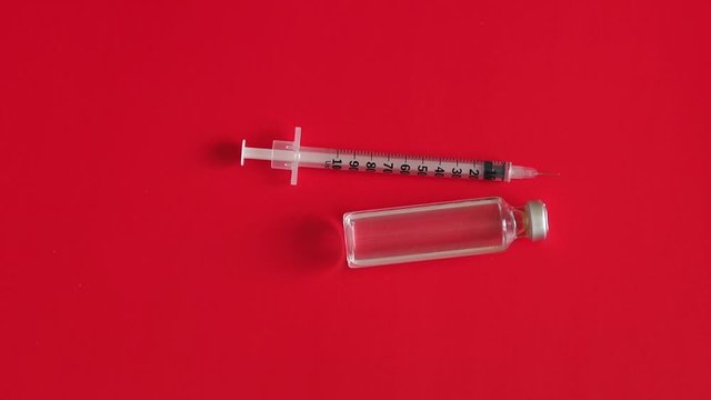 Ampule and insulin syringes on isolated on red background. Insulin medicine bottle and syringe on red background. Type 1 diabetes. Close-up with space for inscription.