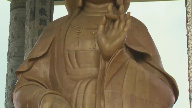 Extreme close-up low-angle tilting shot of goddess of Mercy (Guanyin) holding a sacred vase on one hand and  vitarka mudra gesture on the other, Kek Lok Si Temple, Penang, Malaysia