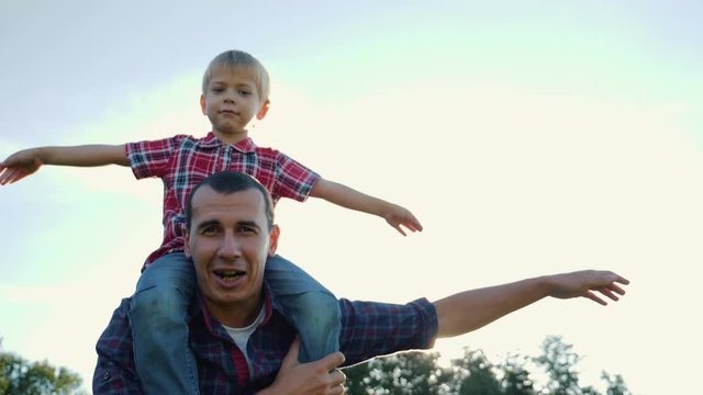 Happy family father and son play with arms wide apart. The game of the plane boy machin hands depicting the wings of an airplane. Teamwork. Family games. Happy family life concept
