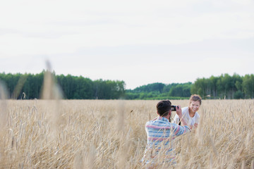 Man taking photograph of his girlfriend or wife in a corn field