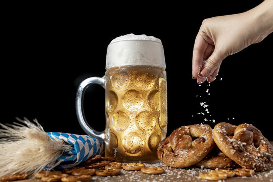 Hand sprinkling salt on bavarian snacks