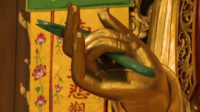 Extreme close-up low-angle still shot of Golden Buddha's Karana Mudra Hand Gesture for expelling or warding off the evil, Kek Lok Si Temple, Penang, Malaysia