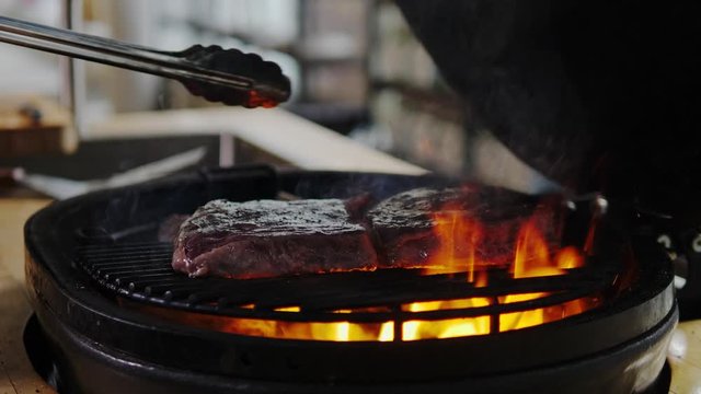 Chef grilling steak in a restaurant