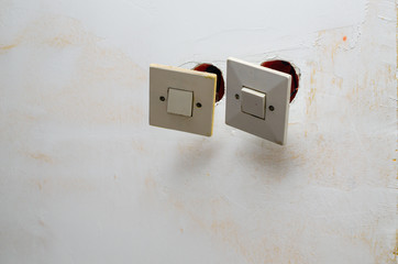 Old switches detached from a wall during renovation works in an apartment